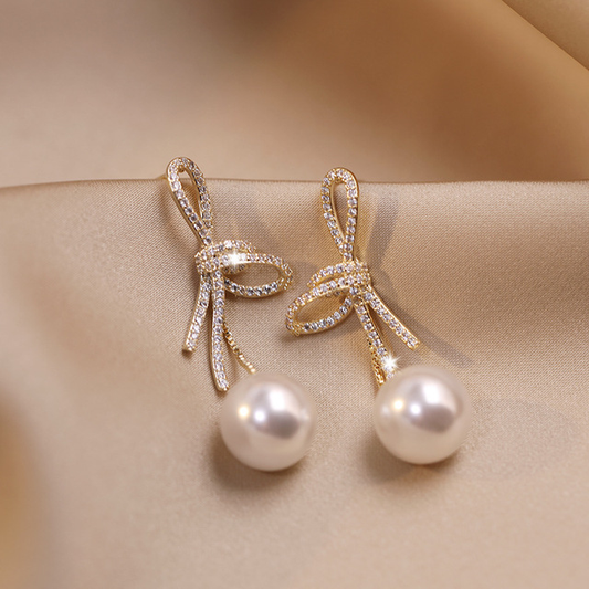 Pendientes de perla con lazo brillante en oro